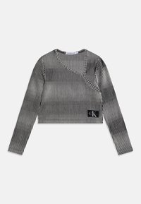 Mustavalkoiraidallinen lyhythihainen yläosa, jossa on erikoinen epäsymmetrinen pääntie ja Calvin Kleinin logopatchi helmassa.