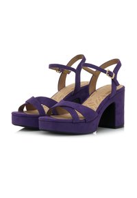 Sandali con tacco alto in suede viola, dotati di una piattaforma spessa, con cinturini incrociati e cinturini alla caviglia con una fibbia dorata. Suola piatta.