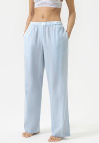 Lichtblauwe pyjamabroek met verticale witte strepen, elastische tailleband, twee zijzakken en een losse pasvorm. Zacht materiaal met een gladde textuur.