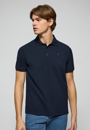 Marineblaue Poloshirt aus Baumwolle mit klassischem Kragen, Drei-Knopf-Leiste und kleinem rotem Logo auf der Brust.