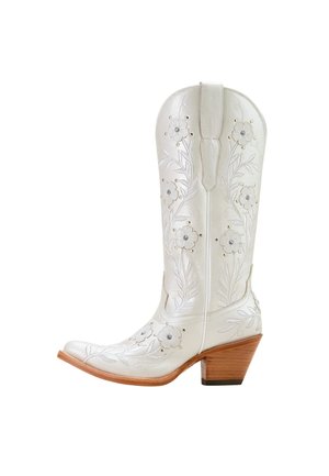 Bota vaquera de cuero blanco con bordado floral, tachuelas plateadas y un tacón apilado de madera de tamaño medio, mostrada de lado sobre un fondo blanco.