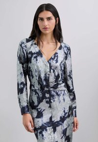 Abito a maniche lunghe in una fantasia tie-dye grigia e blu navy, con scollatura a V e dettaglio arricciato in vita. Tessuto dalla texture liscia.