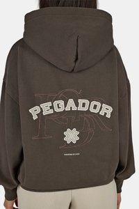 Καφέ φούτερ με μεγάλο γραφικό "PEGADOR" στη πλάτη, που παρουσιάζει γεωμετρικά σχέδια και υφή. Με κουκούλα και ριμπ μανίκια και στρίφωμα.