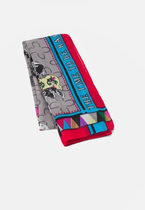 Écharpe colorée pliée avec des motifs géométriques, des imprimés animaliers et un texte indiquant "THE TIME TO BE HA" sur un fond gris, rouge et bleu.