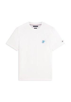 Biała koszulka z krótkim rękawem i okrągłym dekoltem, z niewielkimi niebieskimi, haftowanymi inicjałami na piersi oraz małym logo w postaci flagi na lewym rękawie.