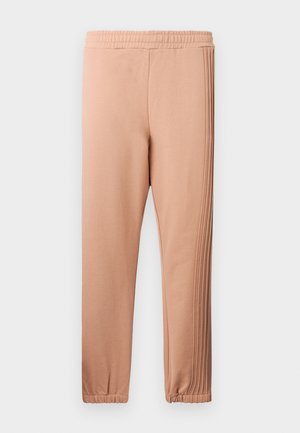 Jasnoróżowe spodnie dresowe z elastycznym pasem, zwężanymi nogawkami i teksturowanymi paskami po bokach. Wykonane z miękkiego materiału, z marszczonymi mankietami przy kostkach.