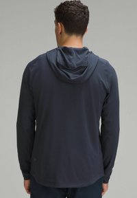 Meeste pikkade varrukatega kapuutsiga särk tumesinisest värvist, lõdva istuvusega, paeltega kapuutsiga ja sileda, tekstuurse kangaga. Minimalistlik bränding detail helmel.