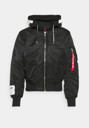 Veste bomber noire avec capuche, fermeture éclair à l'avant, poignets côtelés et ceinture. Étiquette rouge et logo blanc sur la manche. Texture lisse.