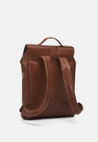 Zaino in pelle marrone con forma rettangolare, finitura testurizzata, maniglia superiore e due spallacci imbottiti. Design compatto con hardware minimale.