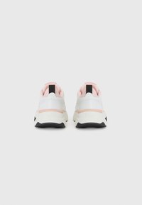 Weiße Sneaker mit einem gepolsterten rosa Kragen und schwarzen Akzenten. Sie verfügen über strukturierte und glatte Materialien, eine Schaumsohle und ein Logodetail an der Ferse.