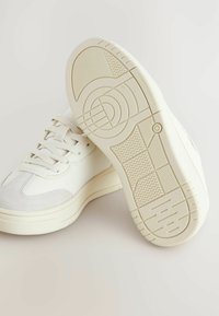 Witte sneakers met een glad leren bovenwerk en suede accenten. Dikke zool met gestructureerde rubberen loopprofielen voor grip.