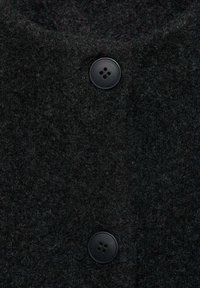 Czarny wełniany płaszcz z teksturowaną powierzchnią, z dwoma czarnymi guzikami z przodu, podkreślającymi jego trwałą konstrukcję.