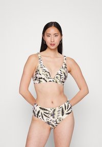 Conjunto de biquíni com um top de decote profundo e calções de cintura alta, feito de tecido elástico com um padrão de folhas tropicais em verde e roxo.