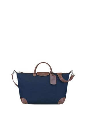Navy blue fabric tote bag with brown leather accents, rounded handles, a detachable shoulder strap, and a luggage tag detail.