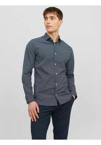 Camicetta abbottonata di colore blu navy con un motivo geometrico, maniche lunghe e colletto classico, realizzata in tessuto testurizzato. Adatta per un look casual.