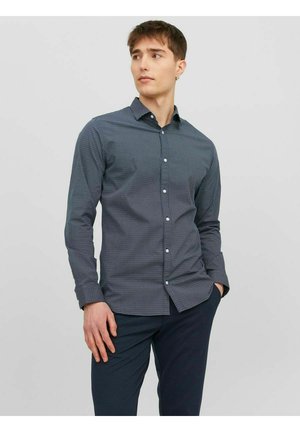 Camicetta abbottonata di colore blu navy con un motivo geometrico, maniche lunghe e colletto classico, realizzata in tessuto testurizzato. Adatta per un look casual.