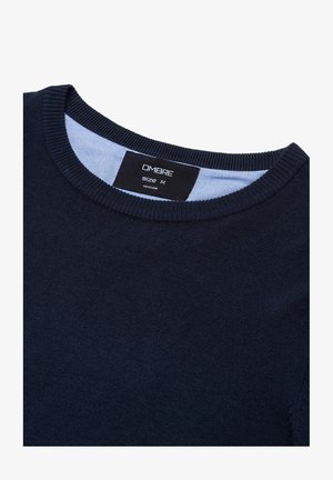 Marineblauwe gebreide pullover met een ronde hals, voorzien van een blauwe accent aan de binnenkant van de kraag. Het label vermeldt "OMBRAE" en maat "M."