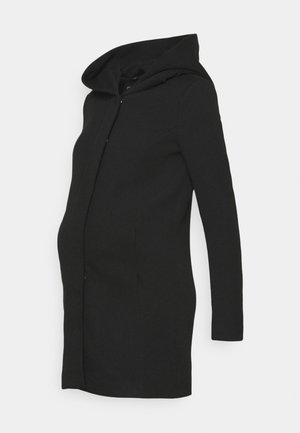 Juodas nėštumo paltas su gobtuvu, pritaikytas ilgis, šoninės kišenės ir glotni tekstūra. Paprastas dizainas su vertikaliai siūlės detale šonuose.