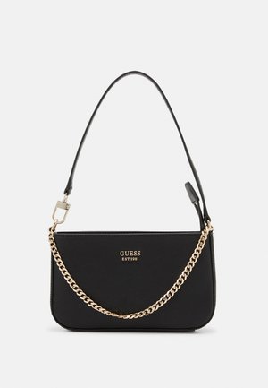Zwarte Guess handtas met gouden ketting en leren band, met het logo "GUESS EST 1981" aan de voorkant.