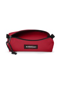 Astuccio rosso realizzato in tessuto resistente, con chiusura a zip, dettagli neri e un'etichetta esterna con logo. L'interno è spazioso.