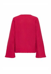 Maglietta rossa a maniche lunghe, strutturata, con un taglio quadrato e scollatura aperta. Il tessuto sembra leggero e leggermente stropicciato, con un design semplice.