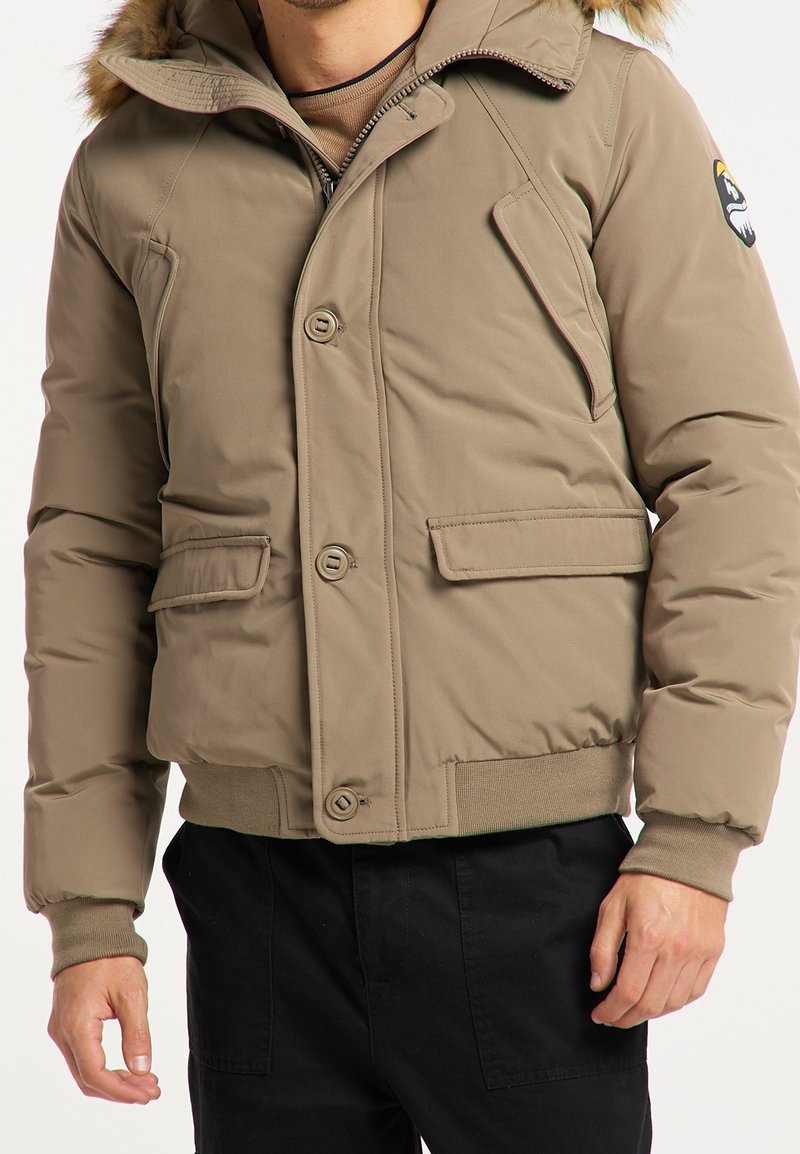 Giubbotto imbottito khaki con cappuccio e bordi in pelliccia sintetica, chiusura anteriore con bottoni, tasche laterali e polsini a costine.