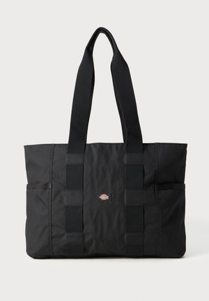 Bolsa tote negra con asas dobles, hecha de tela resistente. Presenta dos bolsillos laterales y un pequeño logo en el centro. Diseño simple y rectangular.