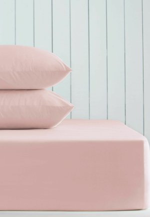 Zwei gestapelte pinke Kissen auf einem pinken Spannbettlaken vor einer hellblauen vertikalen Paneelwand.