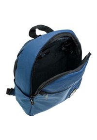Mochila de tela azul con apertura con cremallera, con un interior negro y un bolsillo frontal adicional. Costuras reforzadas y correas ajustables.