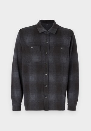 Long-sleeve button-up shirt in black and dark gray plaid pattern, featuring two chest pockets and a standard collar. Smooth fabric texture.
