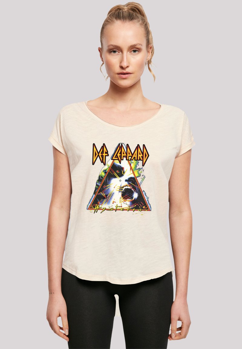 Cremfarbener T-Shirt mit kurzen Ärmeln, das ein großes Grafikdesign einer Pyramide zeigt, mit dem Text "Def Leppard" und "Hysteria" in kräftigen Farben.