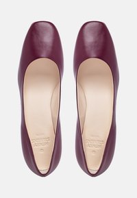 Ballerine in pelle bordeaux con punta quadrata, finitura liscia e interno beige imbottito. Presentano dettagli del marchio sulla soletta.