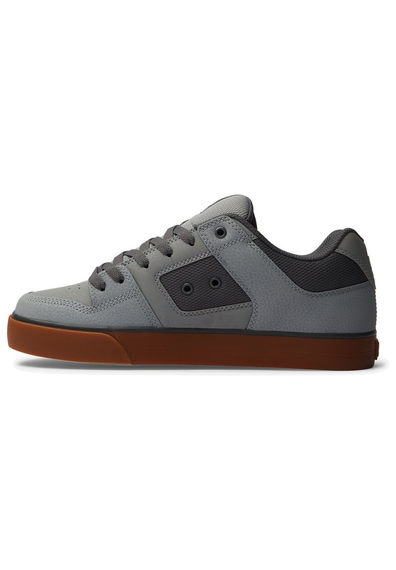 Sneaker grigio con tomaia in pelle testurizzata, accenti in rete grigia e suola in gomma marrone. Caratterizzato da lacci piatti e due fori laterali.