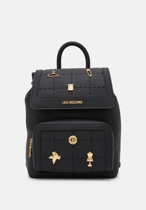 Sort Love Moschino rygsæk med guldfarvede charms med syningstema, inklusive en knap, spole, bøjle, sikkerhedsnål, sløjfe og skrædderbuste.
