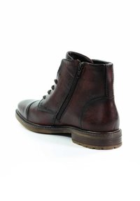 Brązowe skórzane botki za kostkę z okrągłym noskiem, sznurowanym przodem, bocznym zamkiem błyskawicznym i teksturowaną powierzchnią. Solidna podeszwa z widocznymi detalami szycia.