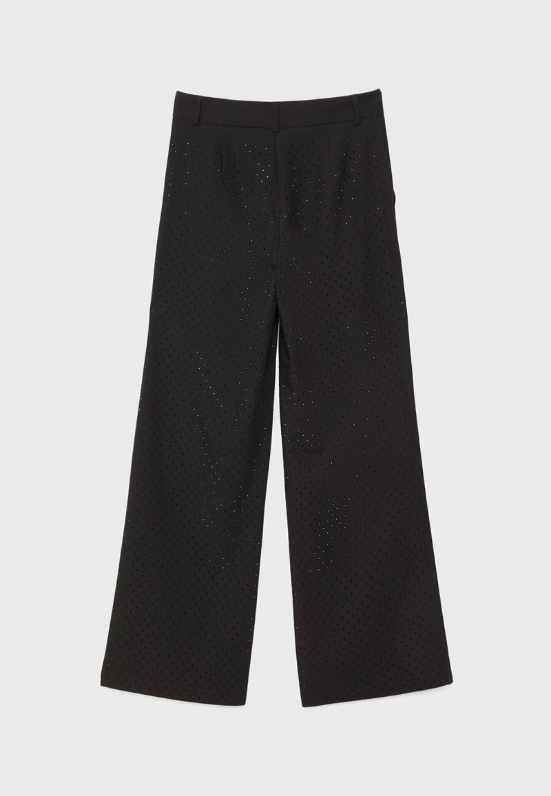 Pantalones de pierna ancha negros hechos de una tela texturizada, con patrones perforados. Diseñados con un corte recto y una cintura de altura media.