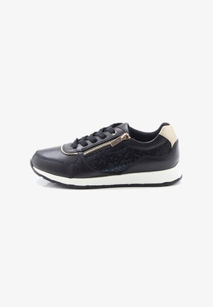 Baskets noires avec semelle blanche, patch beige au talon, fermeture éclair latérale, lacets et motif texturé subtil sur la partie latérale.
