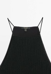 Débardeur noir en maille côtelée avec fines bretelles tressées et encolure carrée, présenté à plat sur un fond blanc.