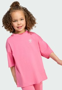 Lyserød oversized t-shirt i blød bomuld med korte ærmer og rund halsudskæring. Har et lille hvidt adidas-logo på brystet.