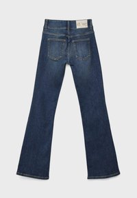 Ciemnoniebieskie dżinsy w stylu dzwonów wykonane z denimu. Charakteryzują się wysokim stanem, dwiema tylnymi kieszeniami oraz tkanym metkiem na pasku. Gładka faktura.