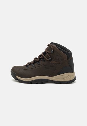 Brown hiking boots made of suede and mesh, featuring a padded collar, lace-up front, and rubber outsole with grip patterns.