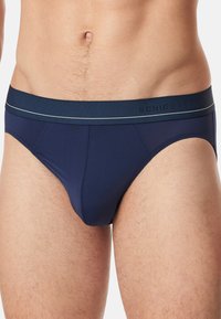 Donkerblauwe boxershort van een gladde, rekbare stof. Kenmerkt zich door een zachte tailleband met het "SCHIESSER"-logo en een contrasterende grijze streep.