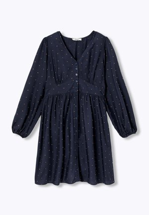 Robe bleu marine longueur genoux avec manches longues bouffantes. Elle présente un devant boutonné, un col en V et de petits pois colorés sur toute la surface.