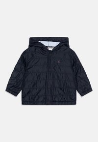Granatowa, pikowana kurtka dla małych dzieci z kapturem, z przodu na zatrzaski, z elastycznymi mankietami i małym logo Tommy Hilfiger na piersi.