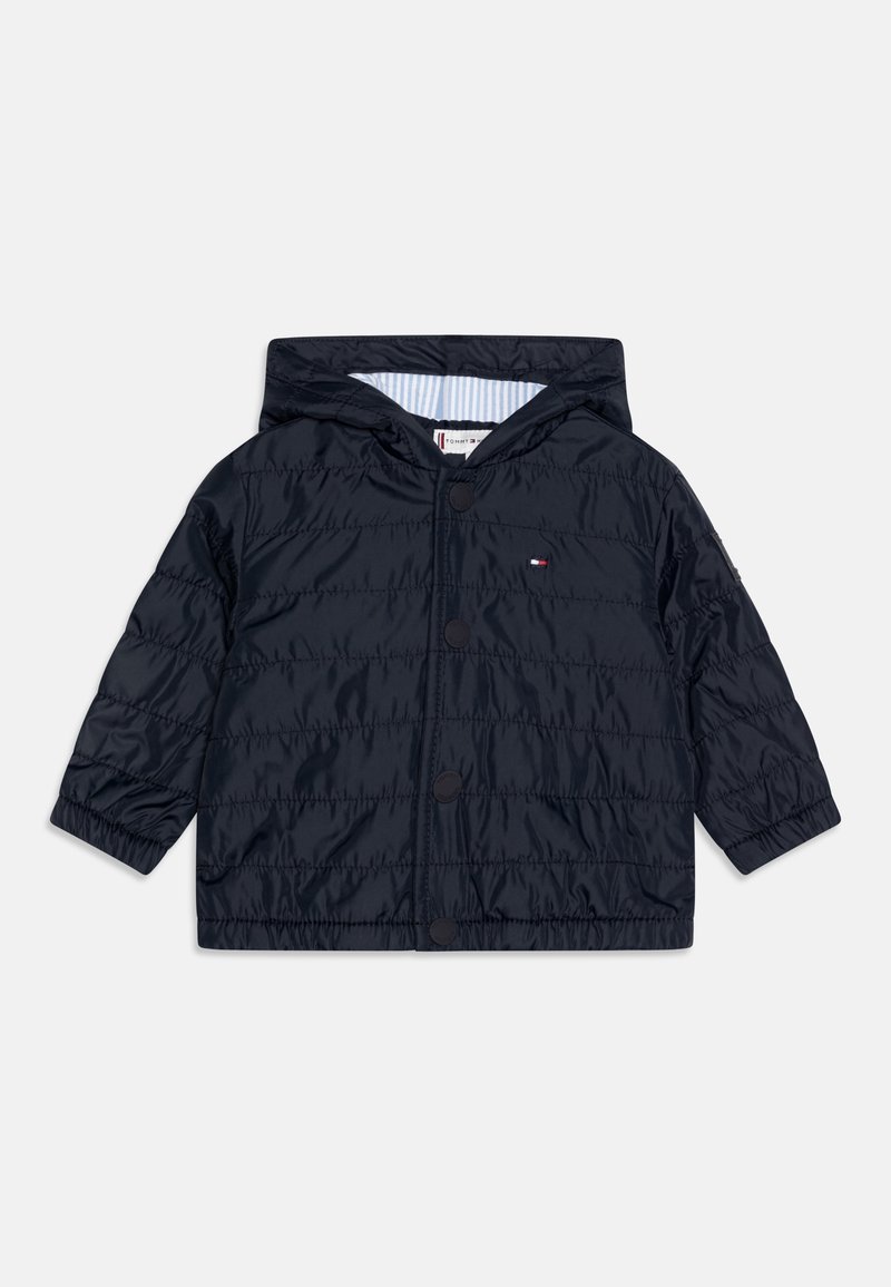 Granatowa, pikowana kurtka dla małych dzieci z kapturem, z przodu na zatrzaski, z elastycznymi mankietami i małym logo Tommy Hilfiger na piersi.