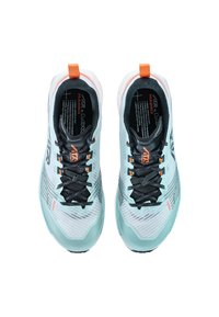 Lichtblauwe sportschoenen met zwarte veters en oranje accenten, gezien van bovenaf. Tekst aan de binnenkant bevat merk- en modelinformatie.
