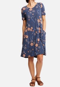 Abito blu navy a maniche corte con stampa floreale in pesca e bianco, caratterizzato da un colletto rotondo e due tasche laterali. Tessuto morbido con una vestibilità rilassata.