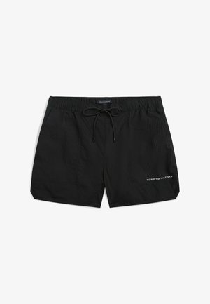 Bañador corto negro para hombre con cintura elástica, cordón negro y logo blanco de Tommy Hilfiger en la pierna izquierda.