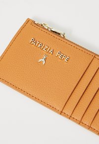 Portafoglio in pelle arancione con finitura testurizzata, dotato di una cerniera dorata e logo impresso. Sono visibili più slot per carte.