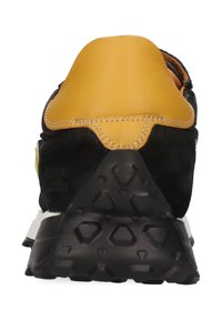 Svarta mocka- och lädersportskor med en gul häl och vit mellansula. Har en texturerad svart gummisula med diamantmönster.